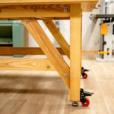 Heavy-duty wooden workbench leg with caster wheels in a professional woodworking shop