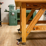 Heavy-duty woodworking bench with locking casters in a workshop setting