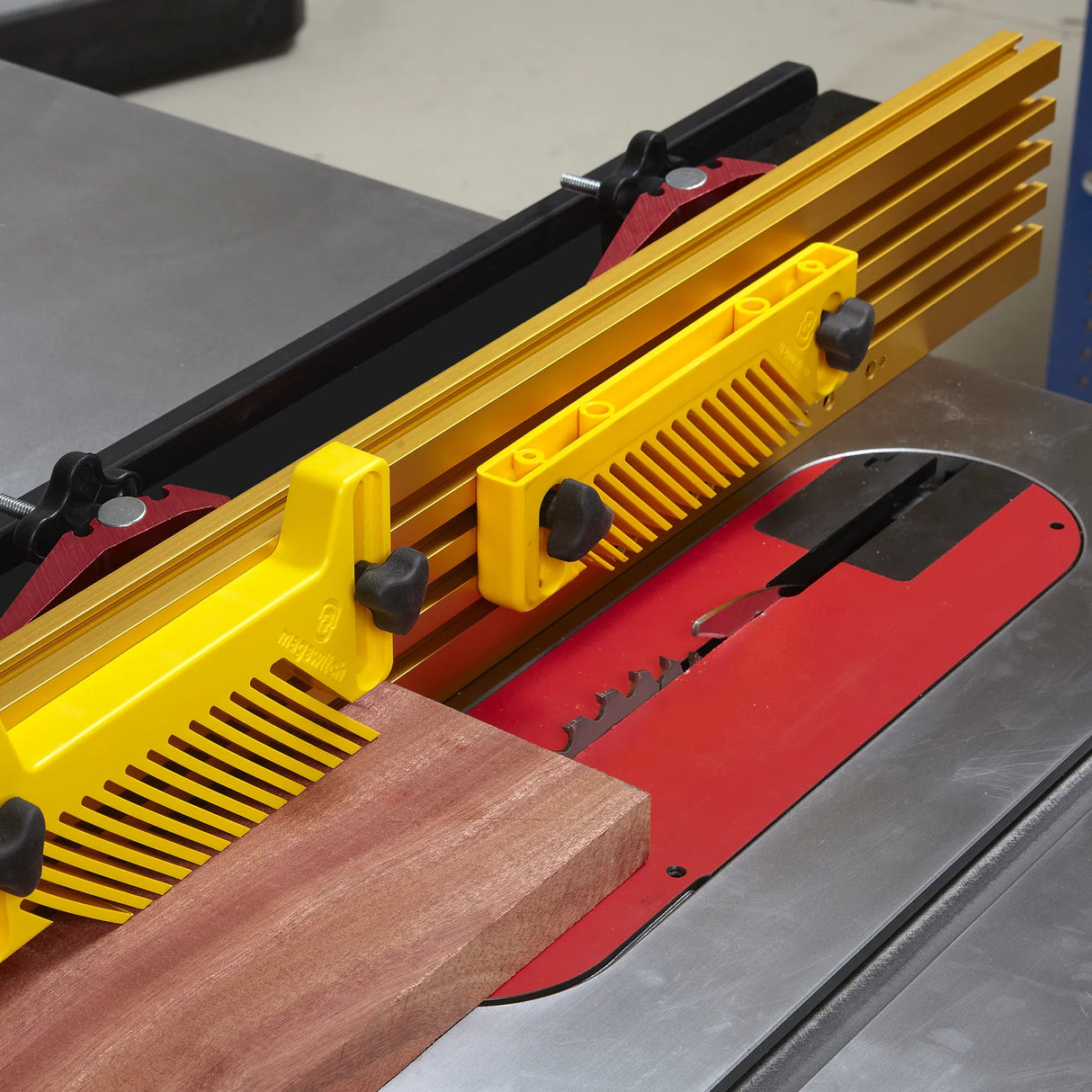 Table saw with featherboard, fence, and wood piece for precise woodworking cuts