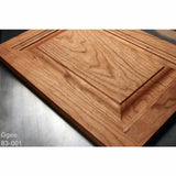 Close-up of cherry wood cabinet door with ogee profile, showcasing detailed woodworking.