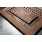 Shaker style cabinet door panel made of walnut wood on a workshop table