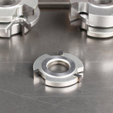 Carbide-tipped woodworking shaper cutter head on a metal surface for precision joinery