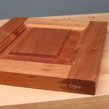 Wooden cabinet door sample with ogee edge profile on a wood workbench