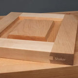Shaker style cabinet door sample with dovetail joinery on a wood workshop table