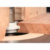 Router bit cutting hardwood edge on router table for woodworking precision