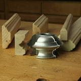Display cutter head with finished wood molding profiles on a woodworking bench