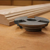 Carbide router bit for woodworking next to moulded wood trim on workbench