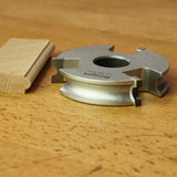 Display cutter woodworking tool with finished wood molding profile on a wooden surface