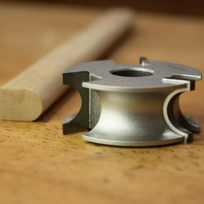 Woodworking display cutter profile with finished wood dowel on a workbench