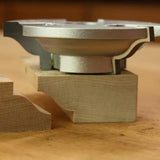 Display cutter tool with finished wood molding profile on a workbench, woodworking accessory