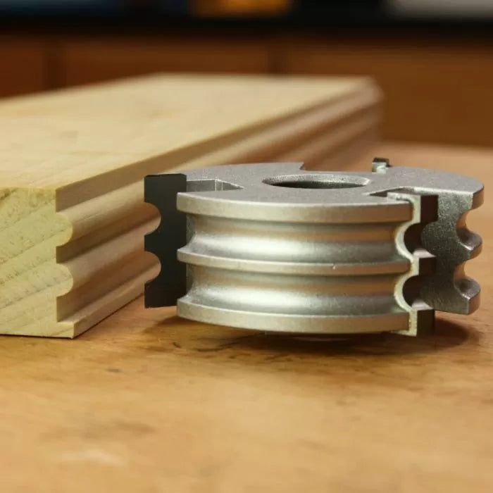 Display cutter tool with detailed molding profile and sample wood on workbench