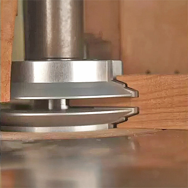 Woodworking router bit cutting decorative edge on hardwood board