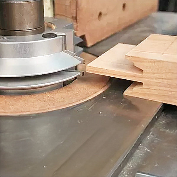 Woodworking shaper cutter creating precise joinery on a wooden board in workshop setting