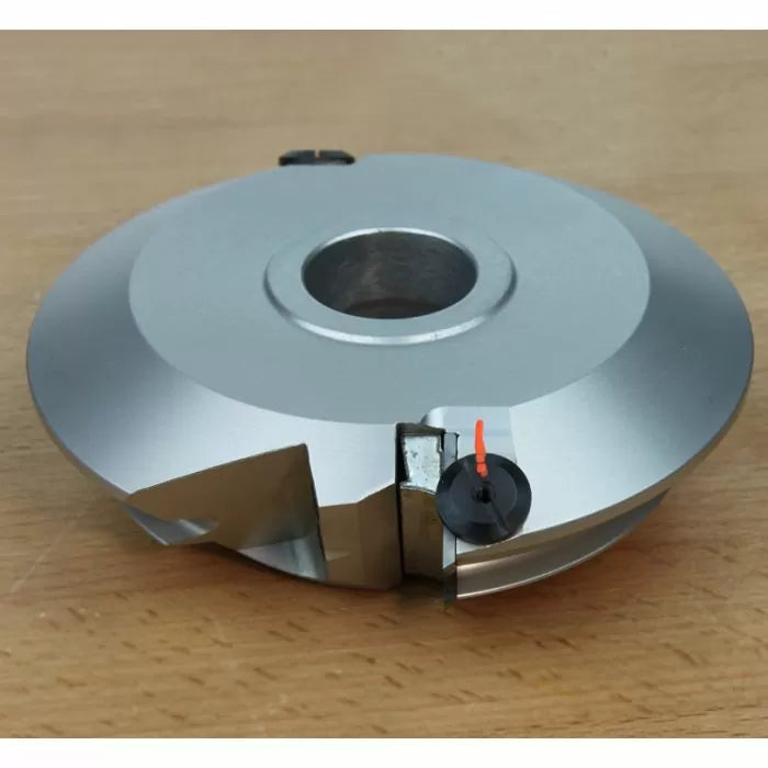 Carbide-tipped woodworking cutter head with steel body on wooden surface