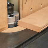 Router table with router bit cutting tongue and groove joint in wood board