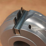 Close-up of precision woodworking router bit cutter head with sharp carbide blades