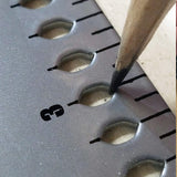 Close-up of marking layout points through the FrameSquare's holes with a pencil