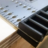Close-up of the Milescraft FrameSquare's fence registered against the edge of a plywood panel