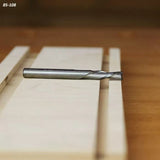 Straight carbide router bit on a wooden board, woodworking tool for precise cutting