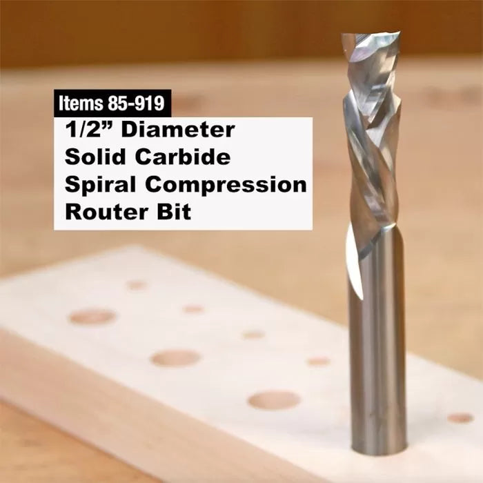 1/2 inch solid carbide spiral compression router bit standing on drilled wood.
