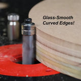 Carbide flush trim router bit creating smooth curved edges on plywood in a router table.
