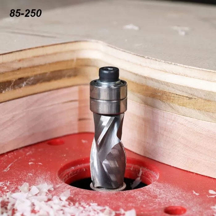 Spiral flush trim router bit mounted in a router table cutting plywood