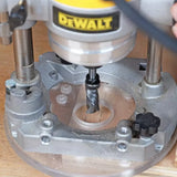 Close-up of woodworking plunge router with spiral bit cutting wood