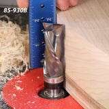 Carbide spiral router bit trimming wood edge, blue ruler for measurement, wood shavings visible