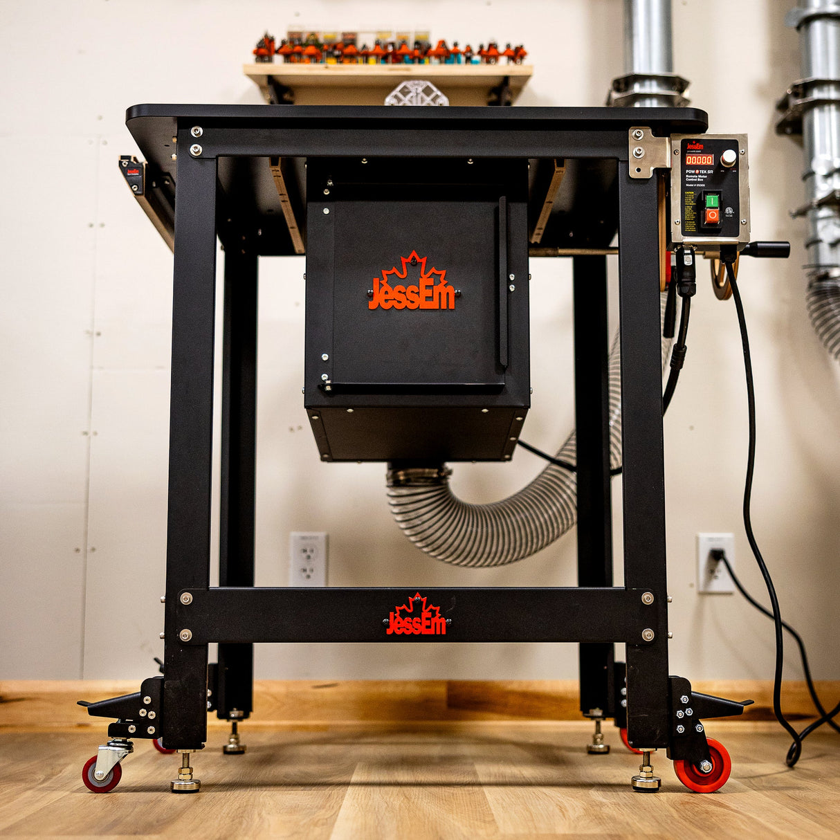 Heavy-duty router table with dust collection hose and digital control panel in workshop