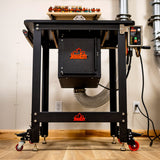 Heavy-duty router table with dust collection hose and digital control panel in workshop