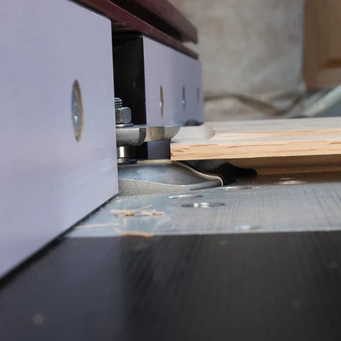 Router table with router bit cutting wood for precise woodworking joinery