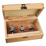 Woodworking router bit set in open wooden case, three steel bits for precision cutting