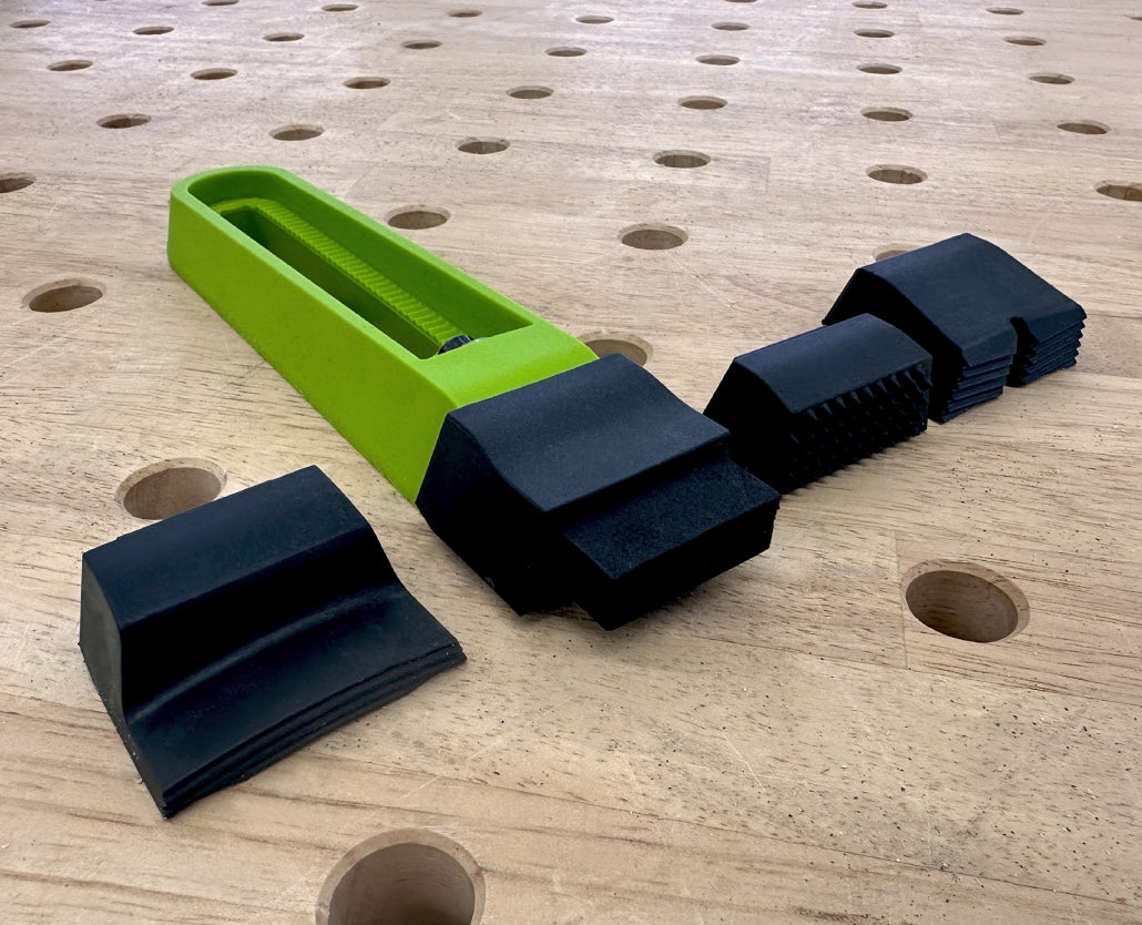 Bow clamps and adjustable bench dog accessories on a perforated woodworking workbench.