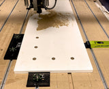CNC router cutting wood panel secured with Bow and Low-Pro clamps, woodworking setup