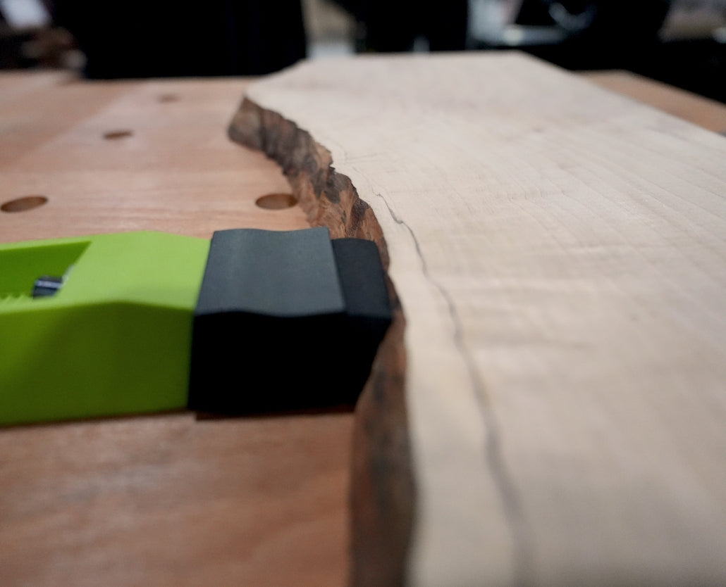 Bow clamp securing live edge wood on a workbench for woodworking projects