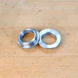 Two metal router table reducer rings on a wooden surface, woodworking tool accessory