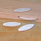 Wood biscuits and biscuit slot in wood plank on workbench for woodworking joinery