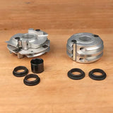 Woodworking cutter heads and bushings set on a wooden surface, precision tool accessories