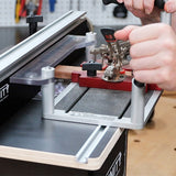 Woodworker using a router table jig to secure wood for precision woodworking cuts