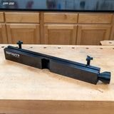 Router table dust collection fence with black aluminum body on a wooden workbench