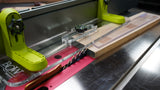 Table saw setup with safety fence, push block, and hardwood board for woodworking