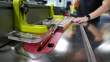 Woodworker using a table saw with a safety jig and push block in a workshop