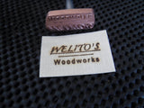 Custom wood branding iron and branded wood tag reading 'WELITO'S Woodworks' on black mat