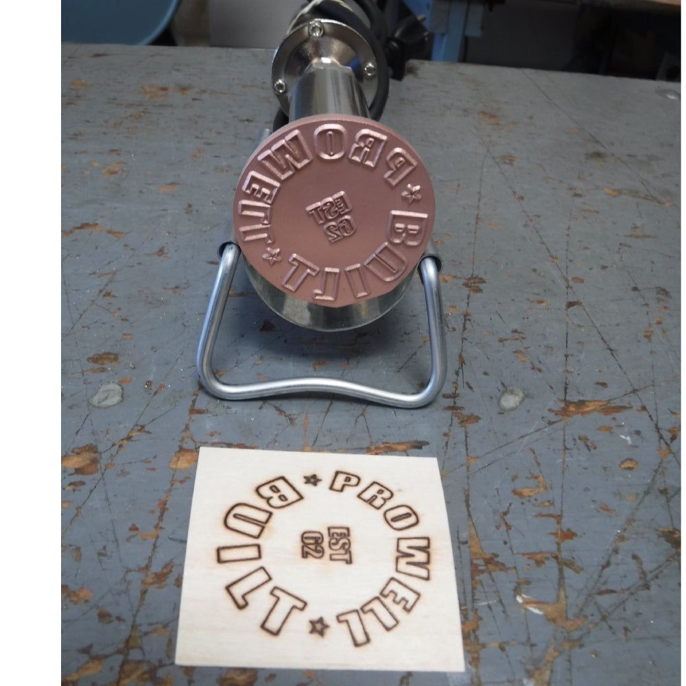 Woodworking branding iron tool and branded wood piece on workshop table