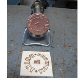 Woodworking branding iron tool and branded wood piece on workshop table