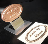 Custom oval branding iron for woodworking with 'made by Mason' woodburned stamp.