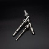 Three metal drill bits with stop collars on a black background, woodworking tool closeup