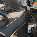 Miter saw jig cutting wood at an angle on a precision woodworking workstation.