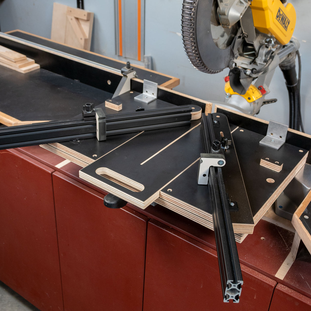 Angle miter jig set up on workbench with sliding fence and miter saw in woodworking shop