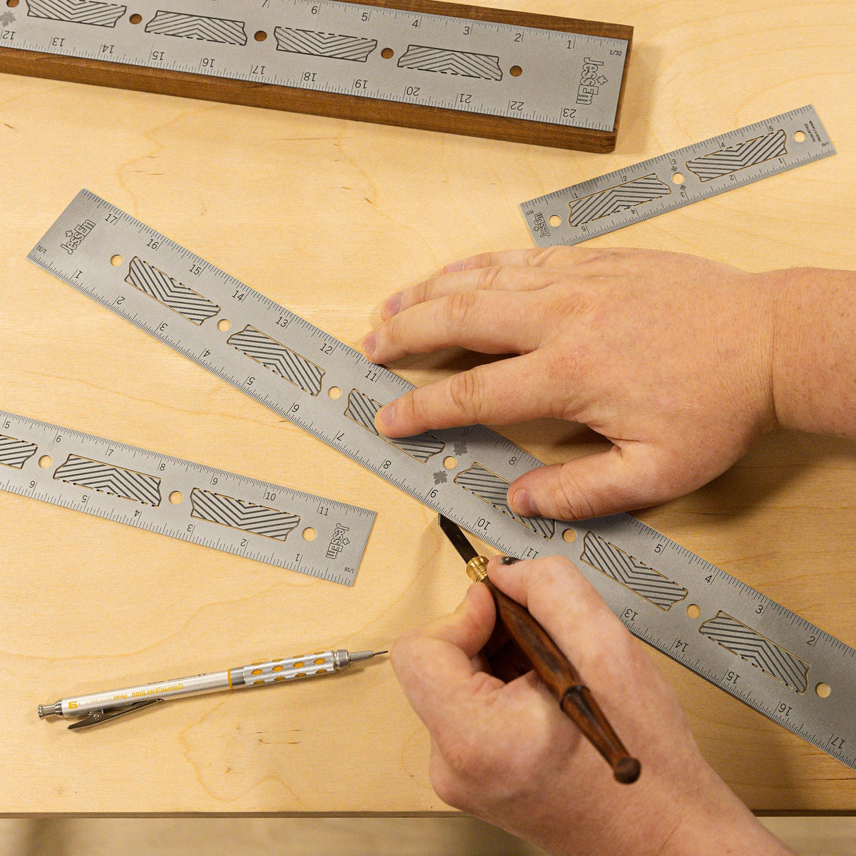 Hands using precision woodworking rulers and marking knife on a wood surface